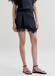woman wearing blue satin and lace top with matching mini skirt