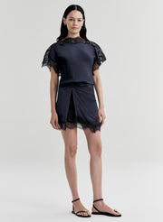 woman wearing blue satin and lace top with matching mini skirt