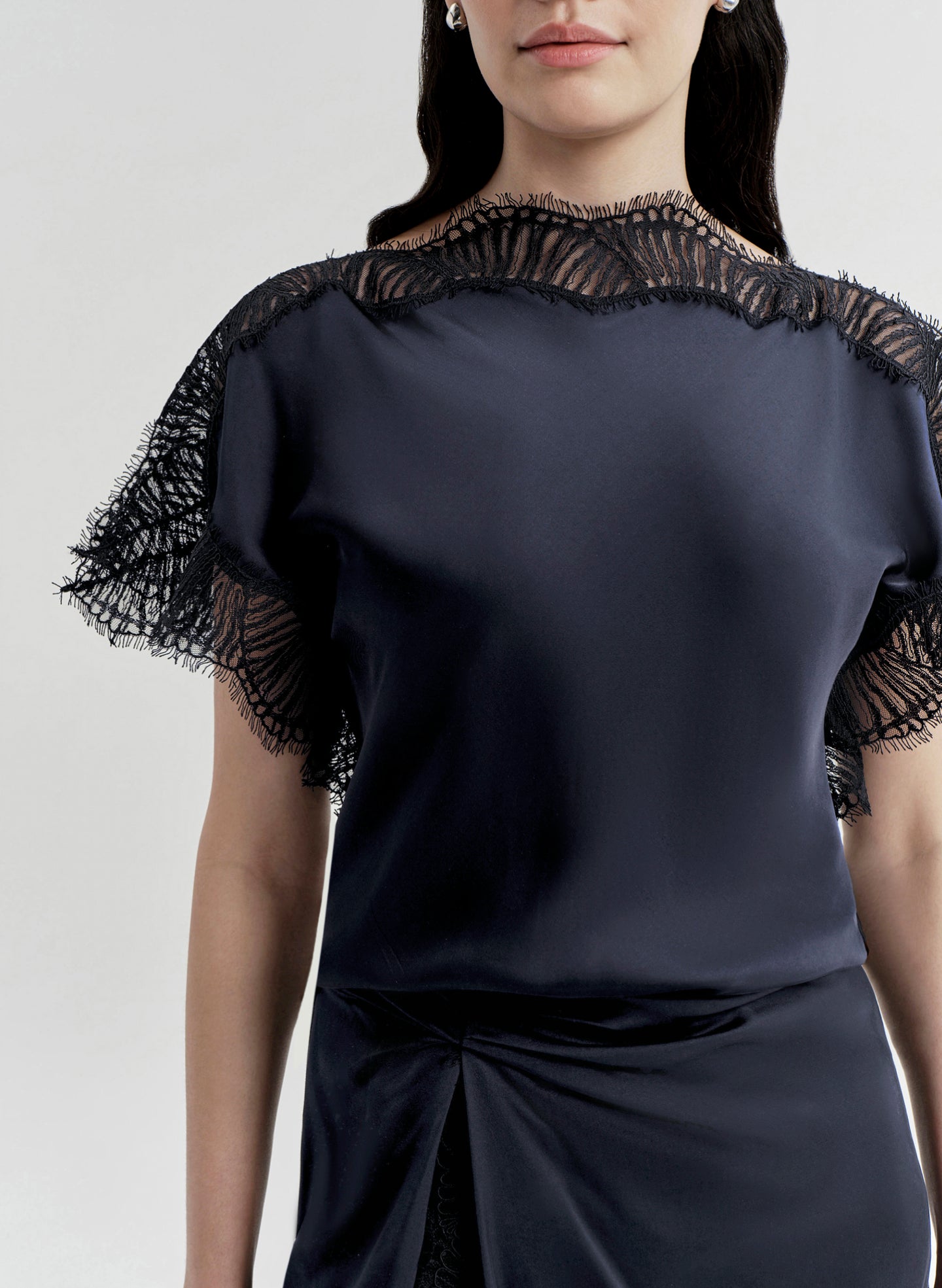 Navy blue top with lace sleeves on a plain background