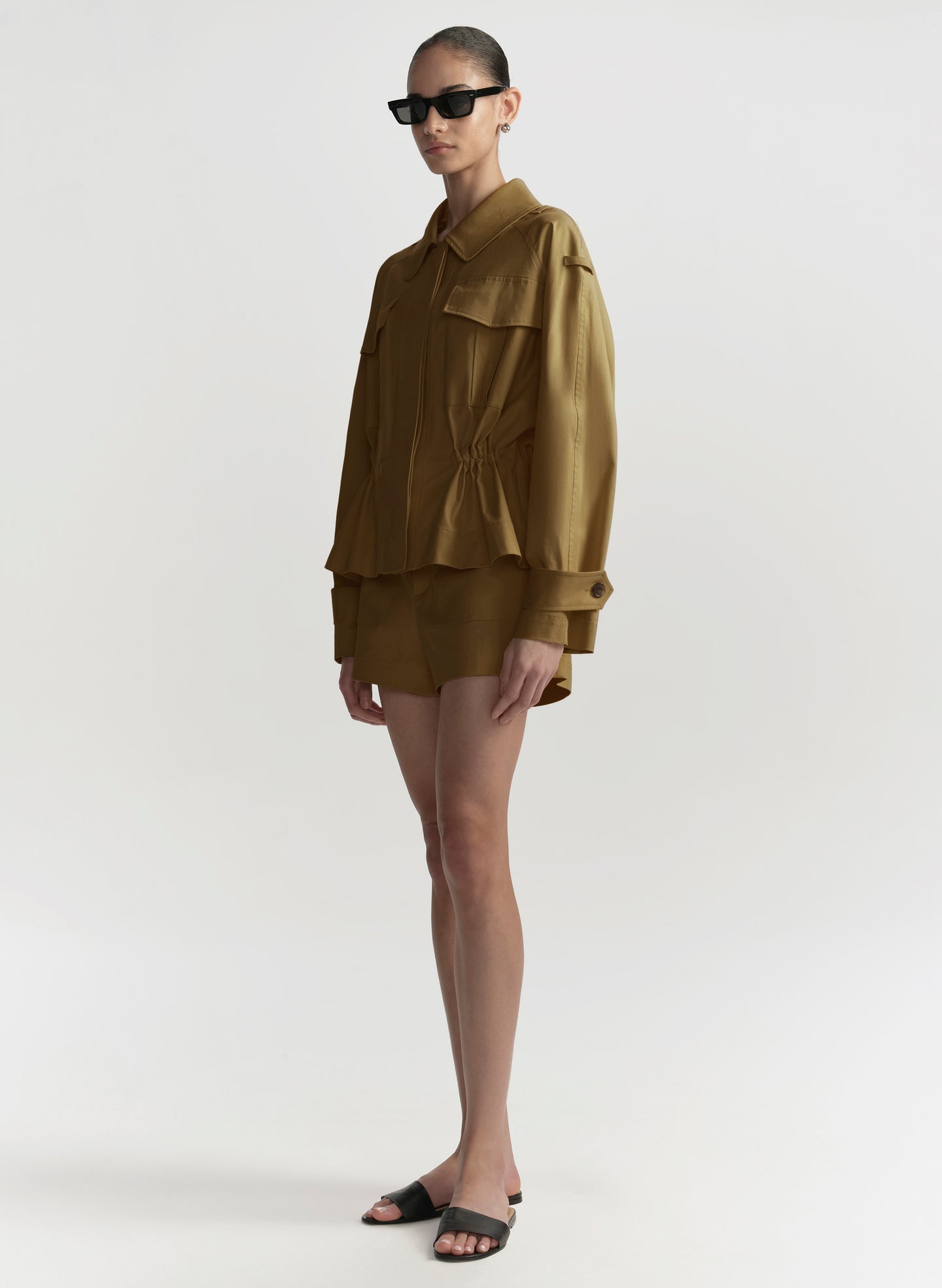 Person wearing a hazel brown outfit on a white background