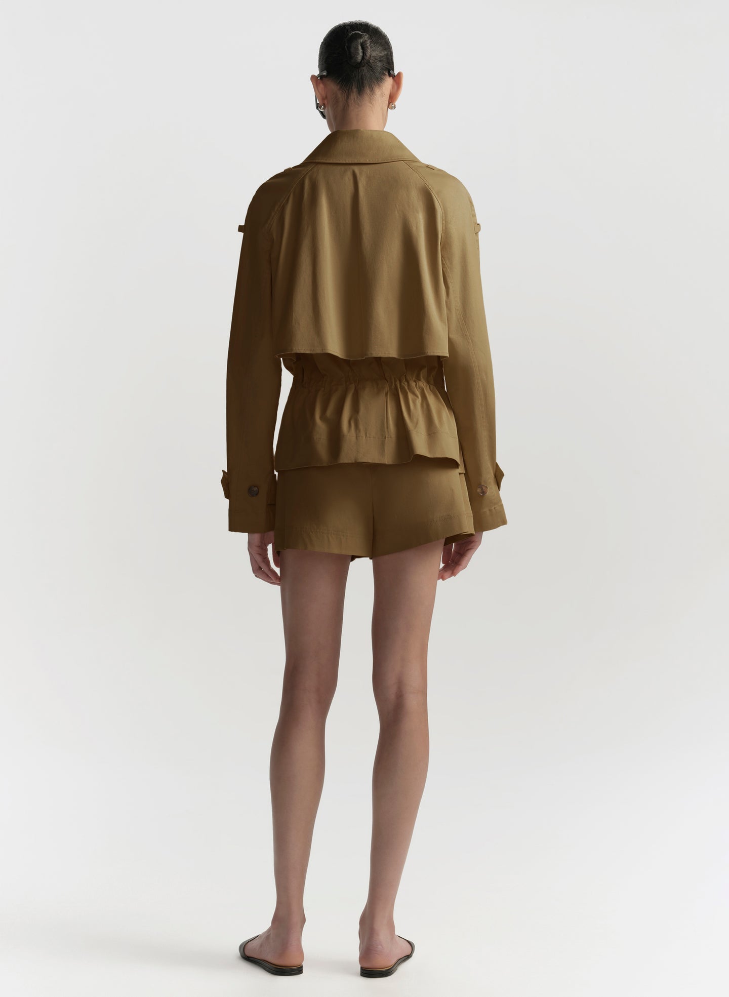 woman wearing a hazel brown jacket and shorts