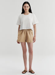 woman wearing white tshirt and tan shorts