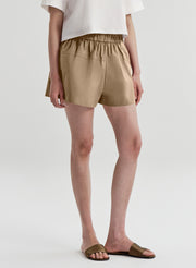 Person wearing beige shorts on a white background