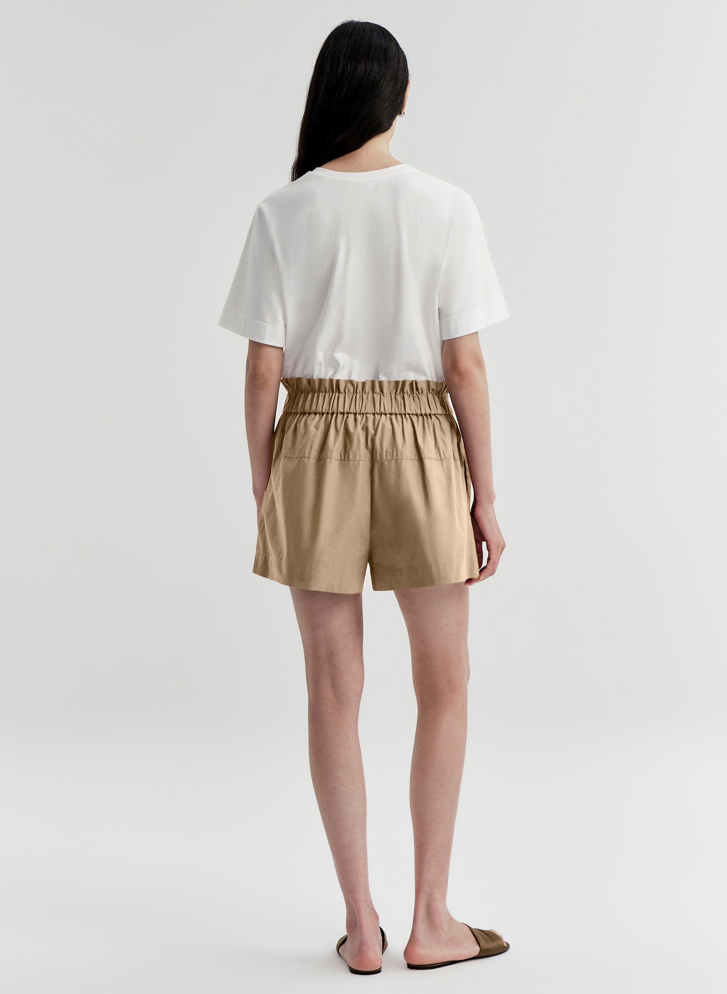 woman wearing white tshirt and tan shorts