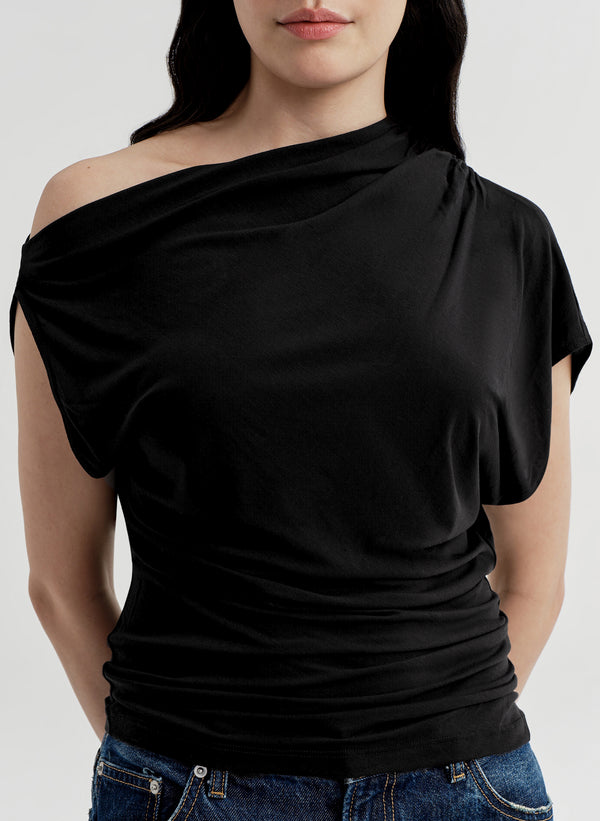 Black off-shoulder top worn by a person on a white background