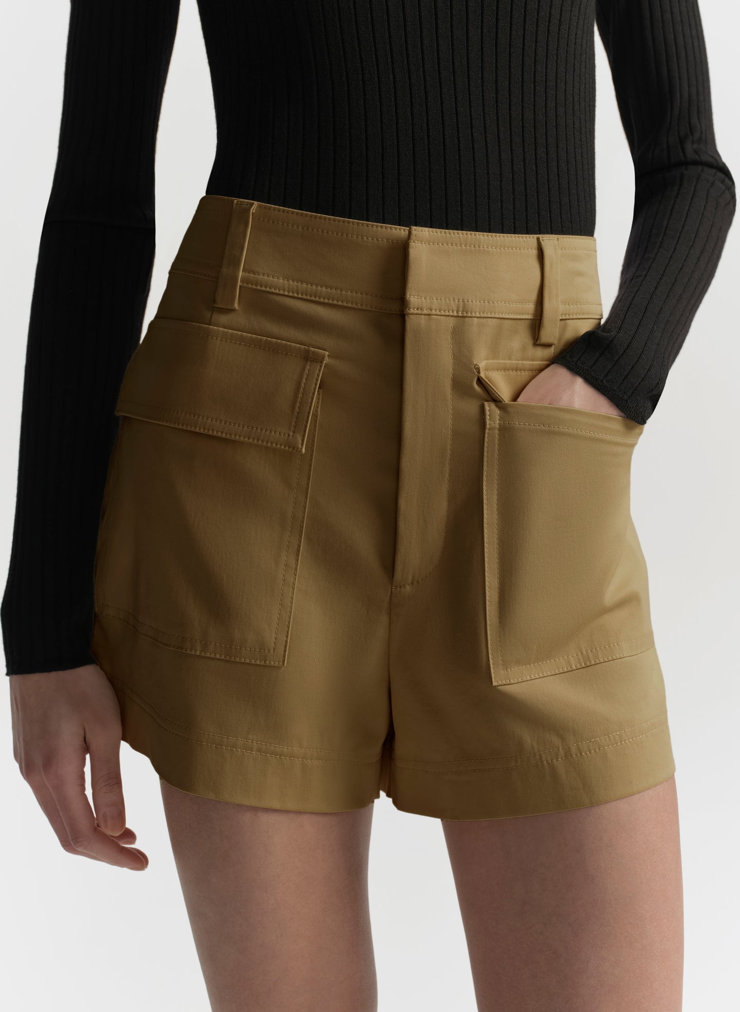 Person wearing hazel brown shorts with a plain background