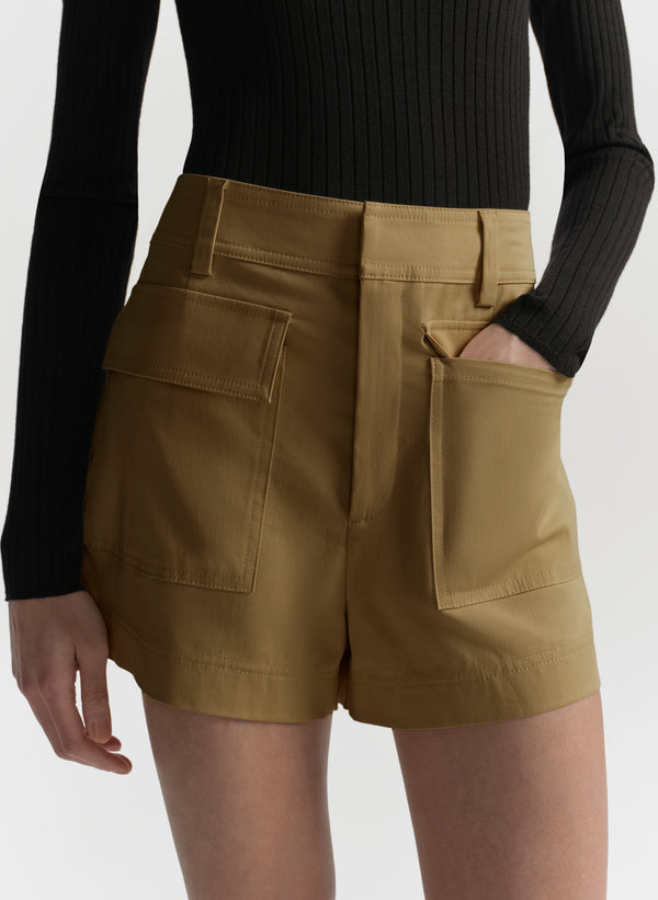 Person wearing hazel brown shorts with a plain background