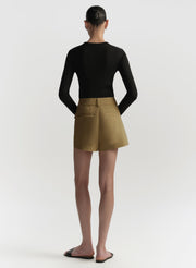 Person wearing a black top and brown shorts on a white background