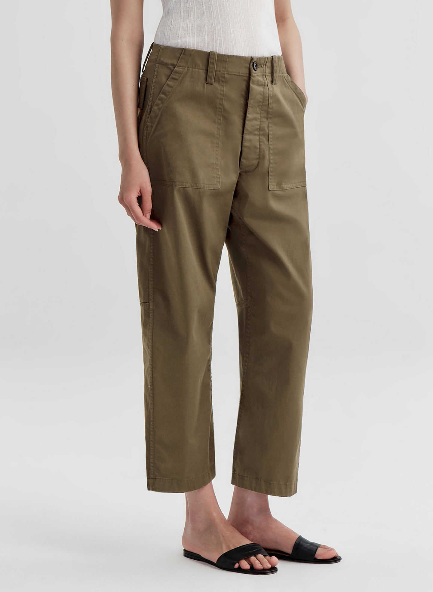 Person wearing olive green pants on a white background