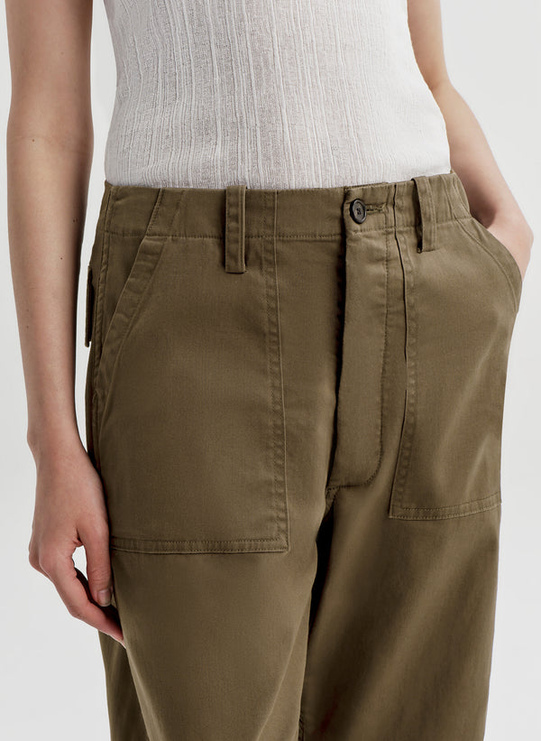 Person wearing olive green pants on a light gray background
