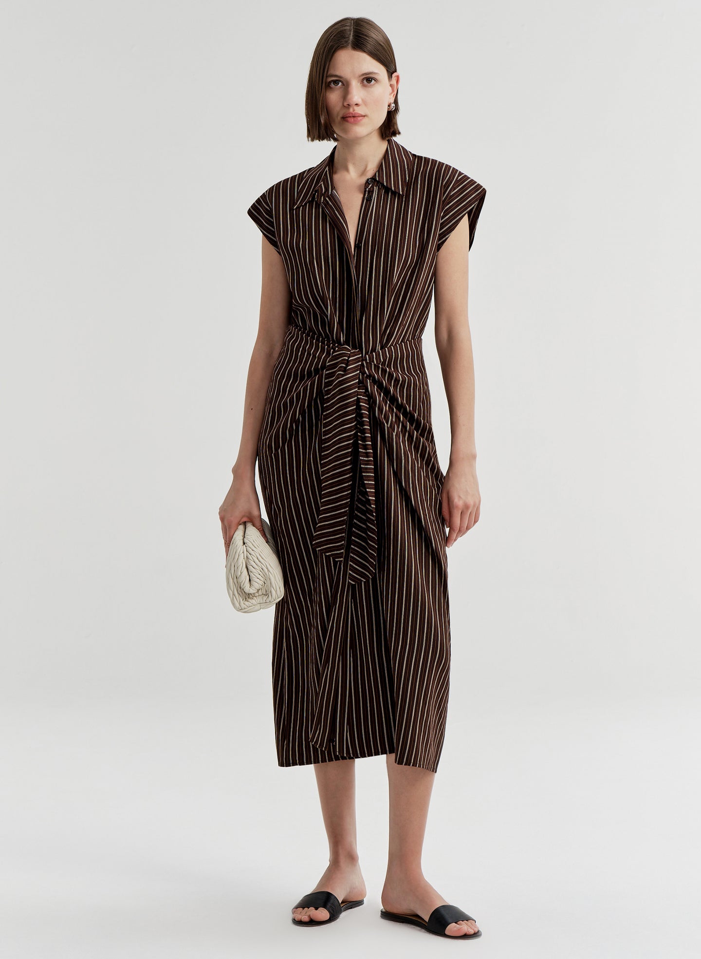 Woman wearing a brown and black striped dress on a white background