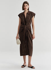 Woman wearing a brown and black striped dress on a white background