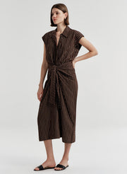 Woman wearing a brown and black striped dress on a white background