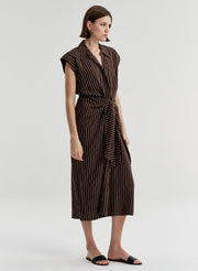 Woman wearing a brown and black striped dress on a white background