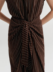 Brown and white striped dress with a tie waist on a plain background