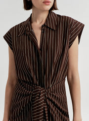 Brown and white striped dress worn by a model on a plain background