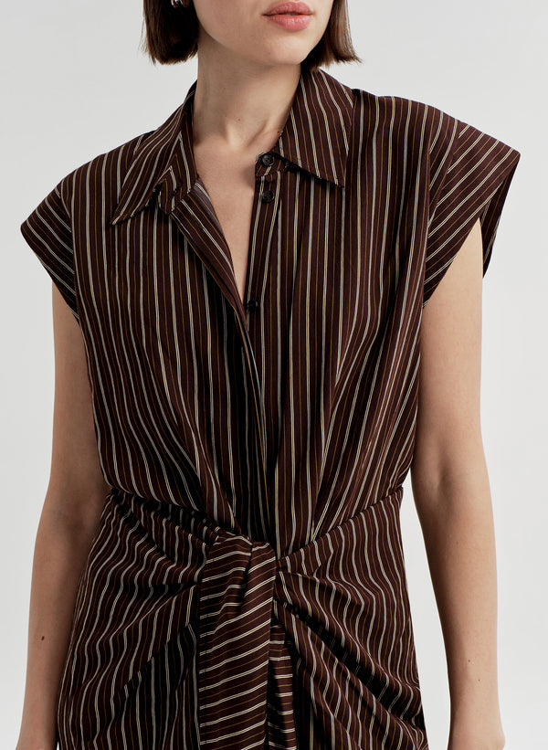 Brown and white striped dress worn by a model on a plain background