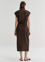 Woman wearing a brown and white striped dress on a white background