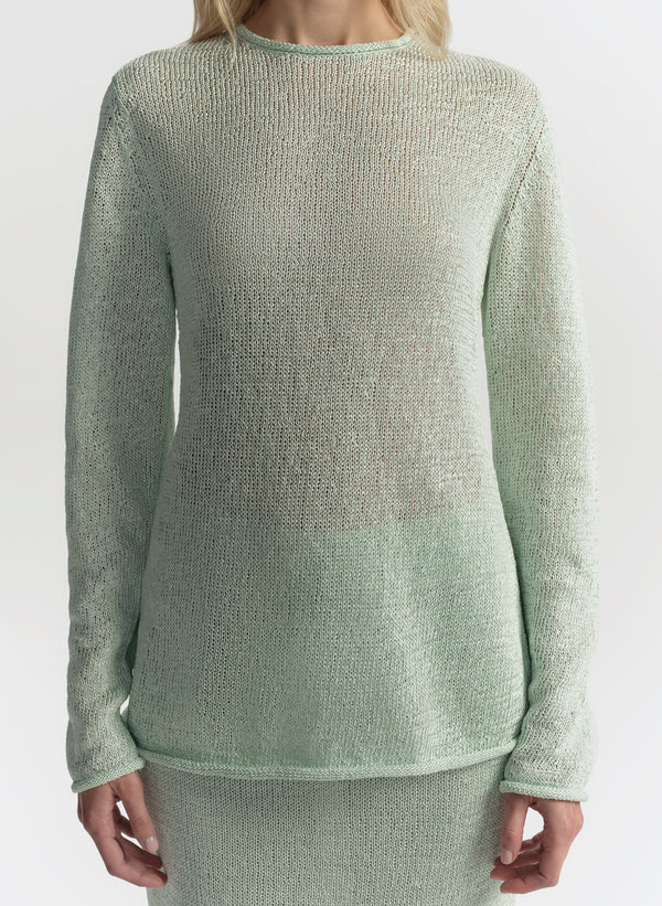 Green textured sweater worn by a person on a white background