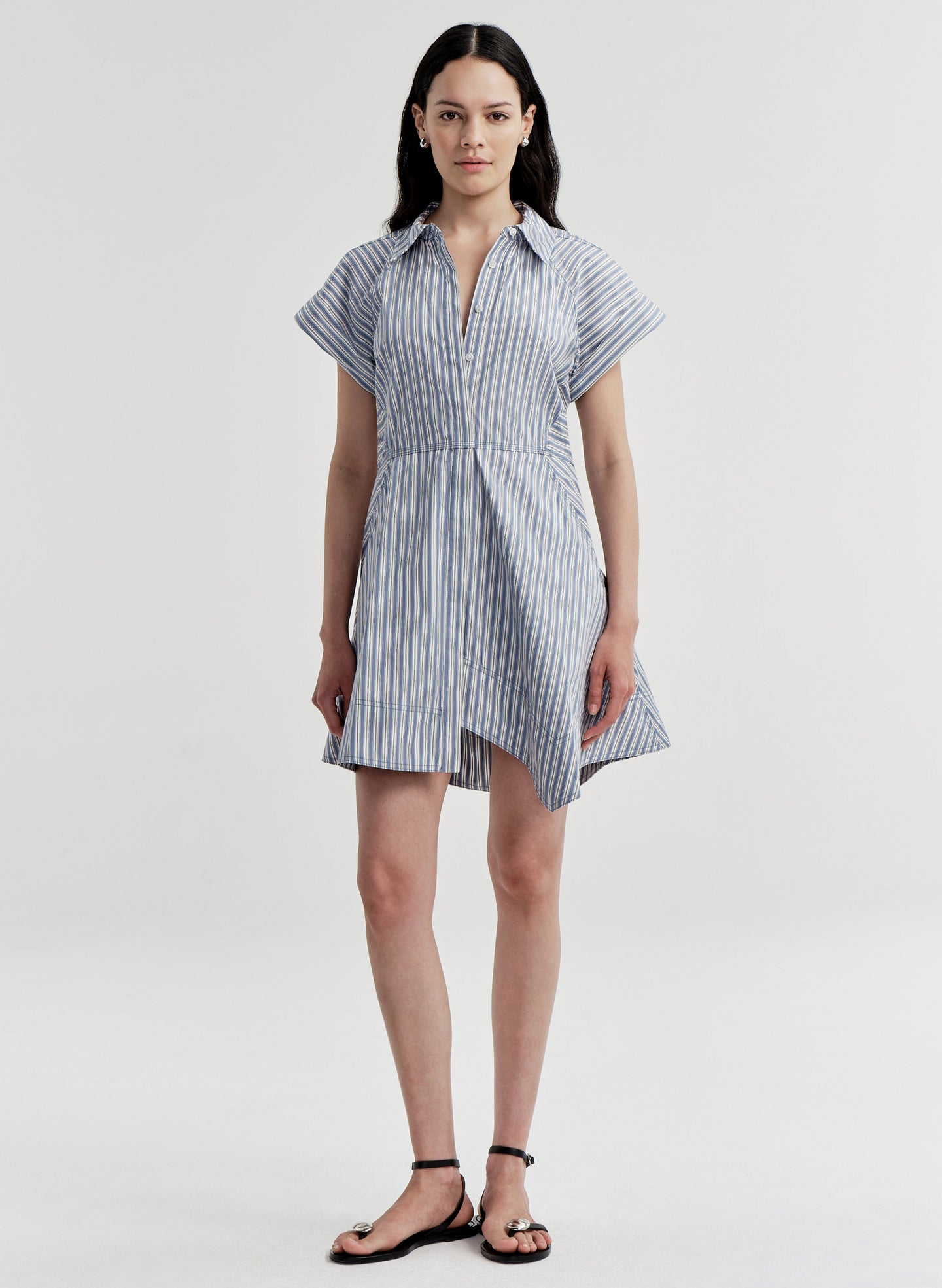 Woman wearing a blue and white striped dress on a white background