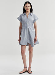 Woman wearing a blue and white striped dress on a white background