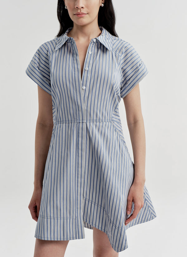 Woman wearing a blue and white striped dress on a light gray background