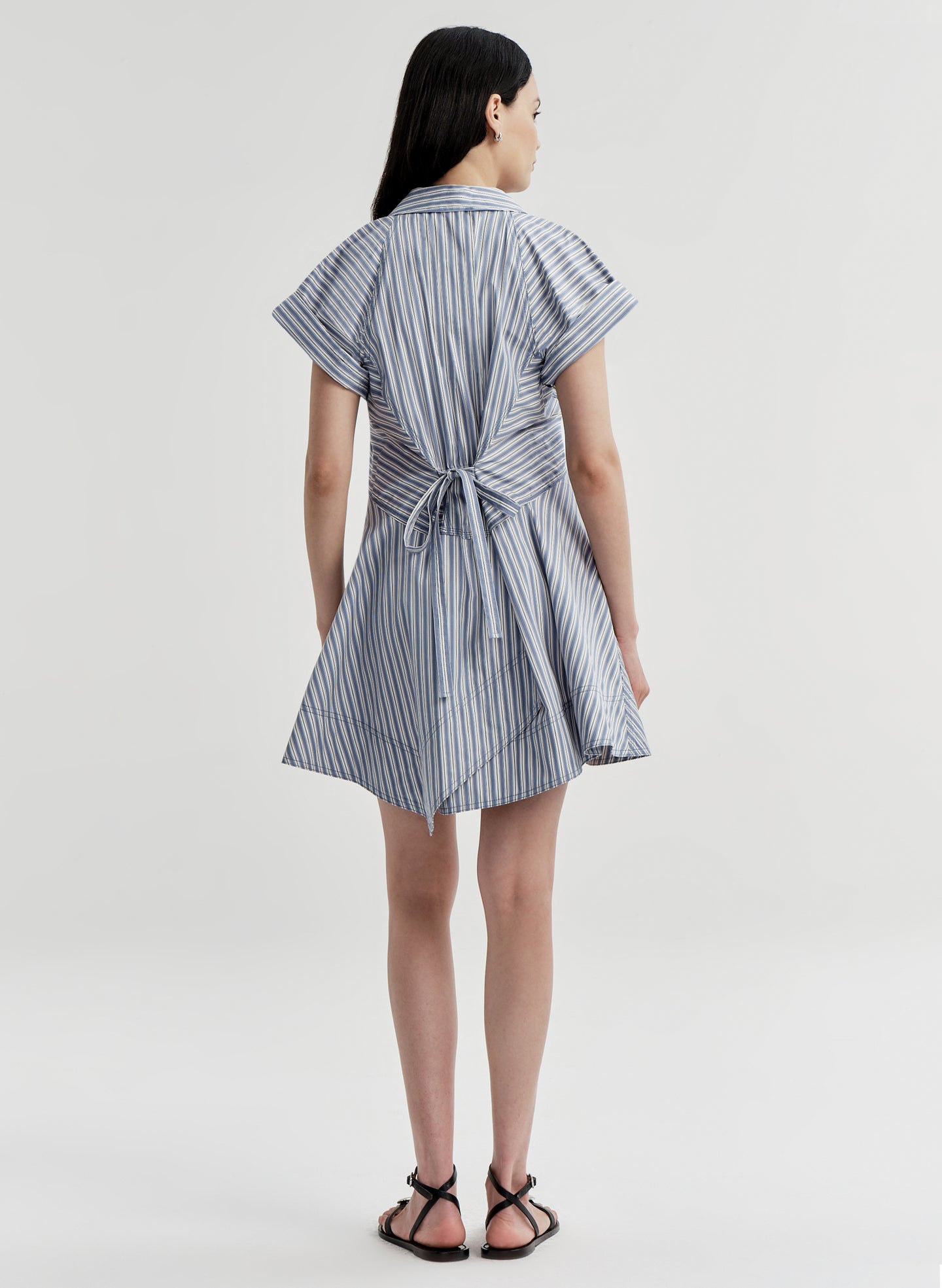 Woman wearing a blue and white striped dress on a white background