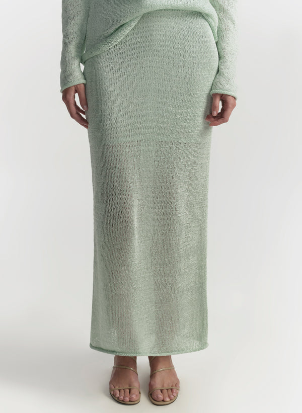 Person wearing a long green skirt on a white background
