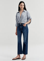 Woman wearing a striped shirt and blue jeans on a white background