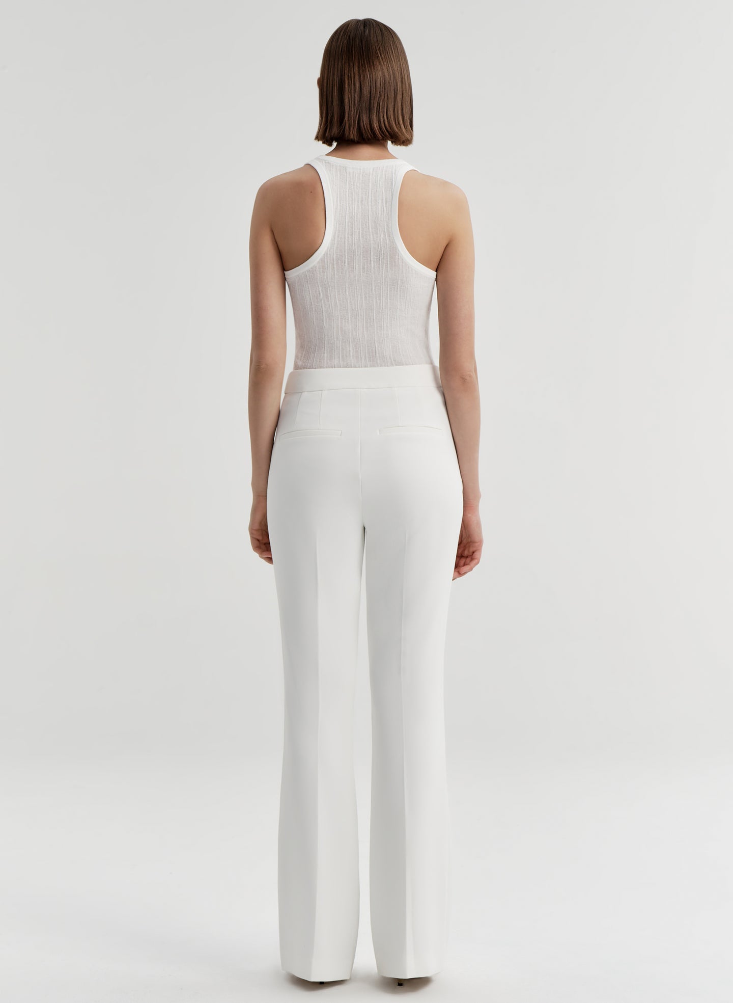 woman wearing white tank top and white pants