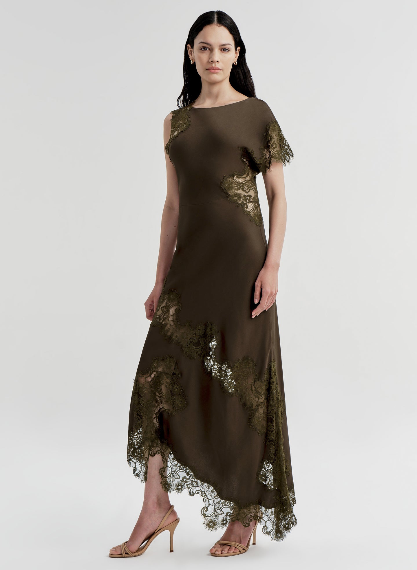 Woman wearing a brown dress with lace details on a white background