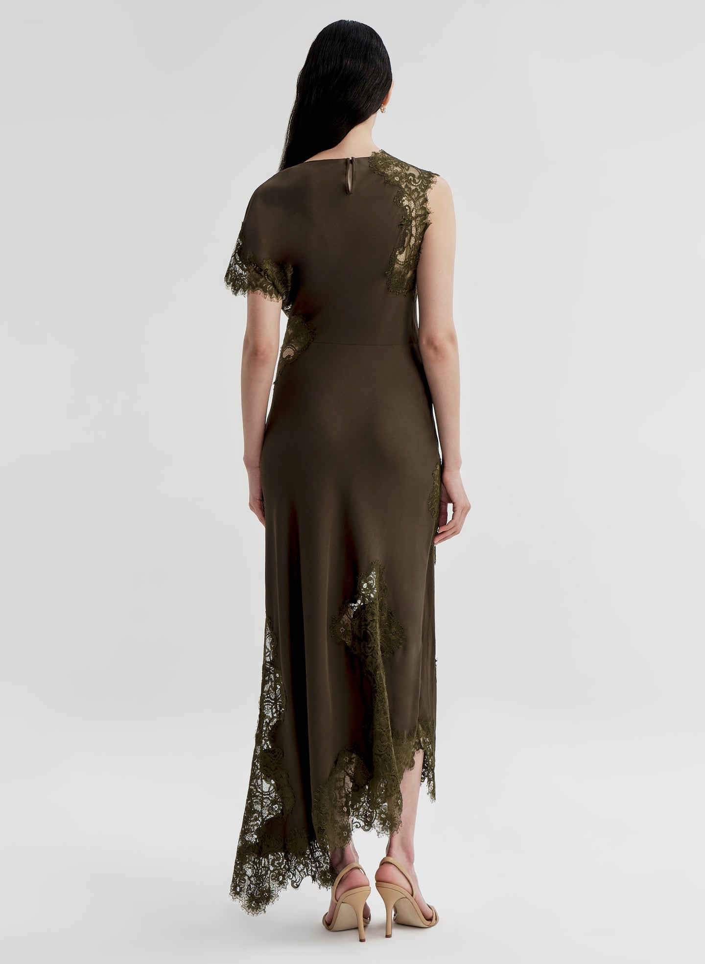 Woman wearing a brown dress with lace details on a white background