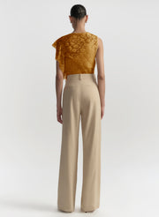 woman wearing beige pants and gold lace top