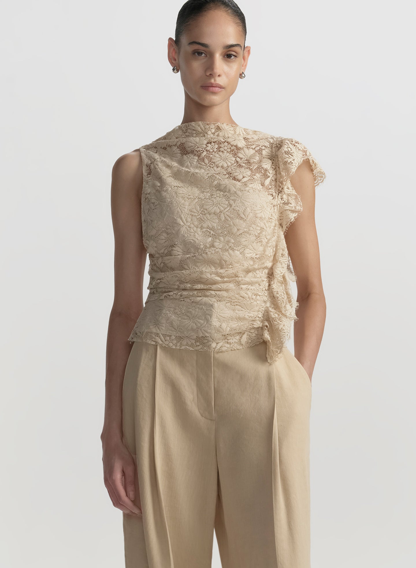woman wearing cream lace top and tan pants