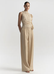 woman wearing cream lace top and tan pants