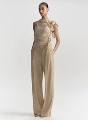 woman wearing cream lace top and tan pants