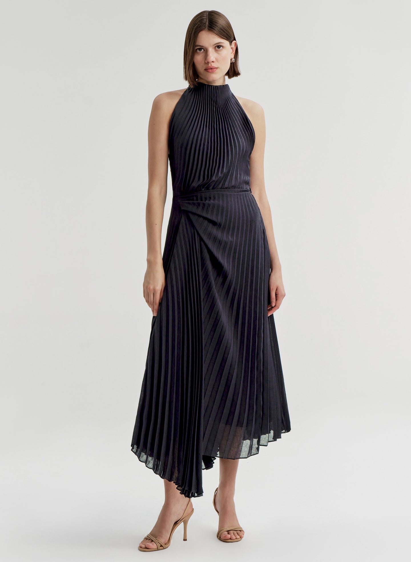 Woman wearing a blue pleated dress on a white background