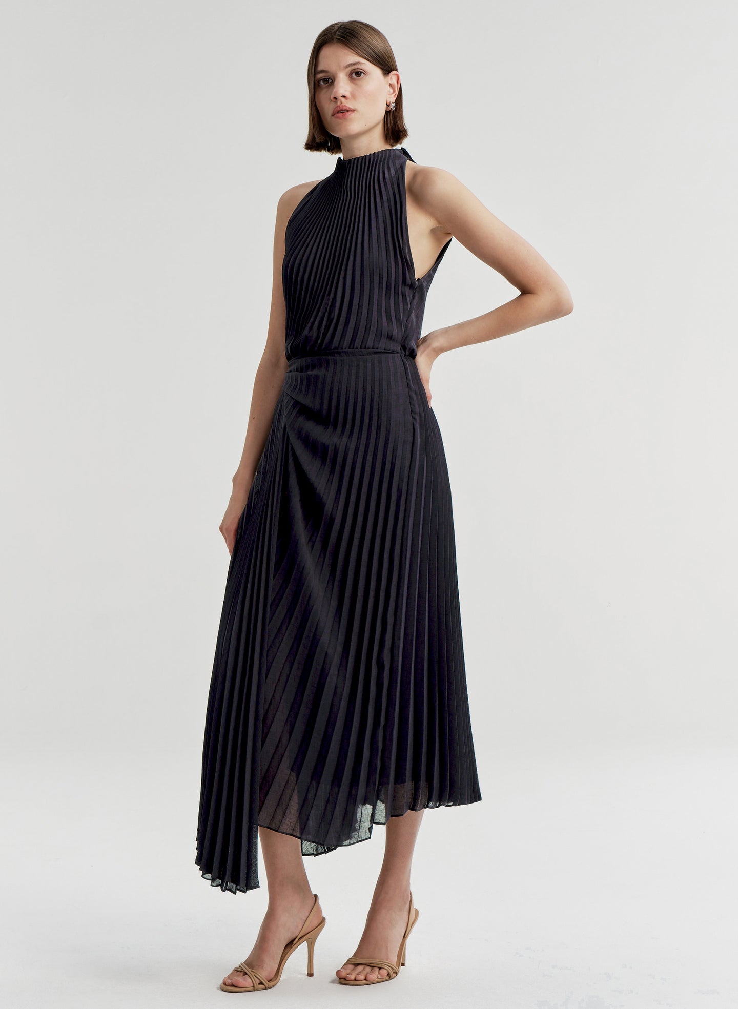 Woman wearing a blue pleated dress on a white background