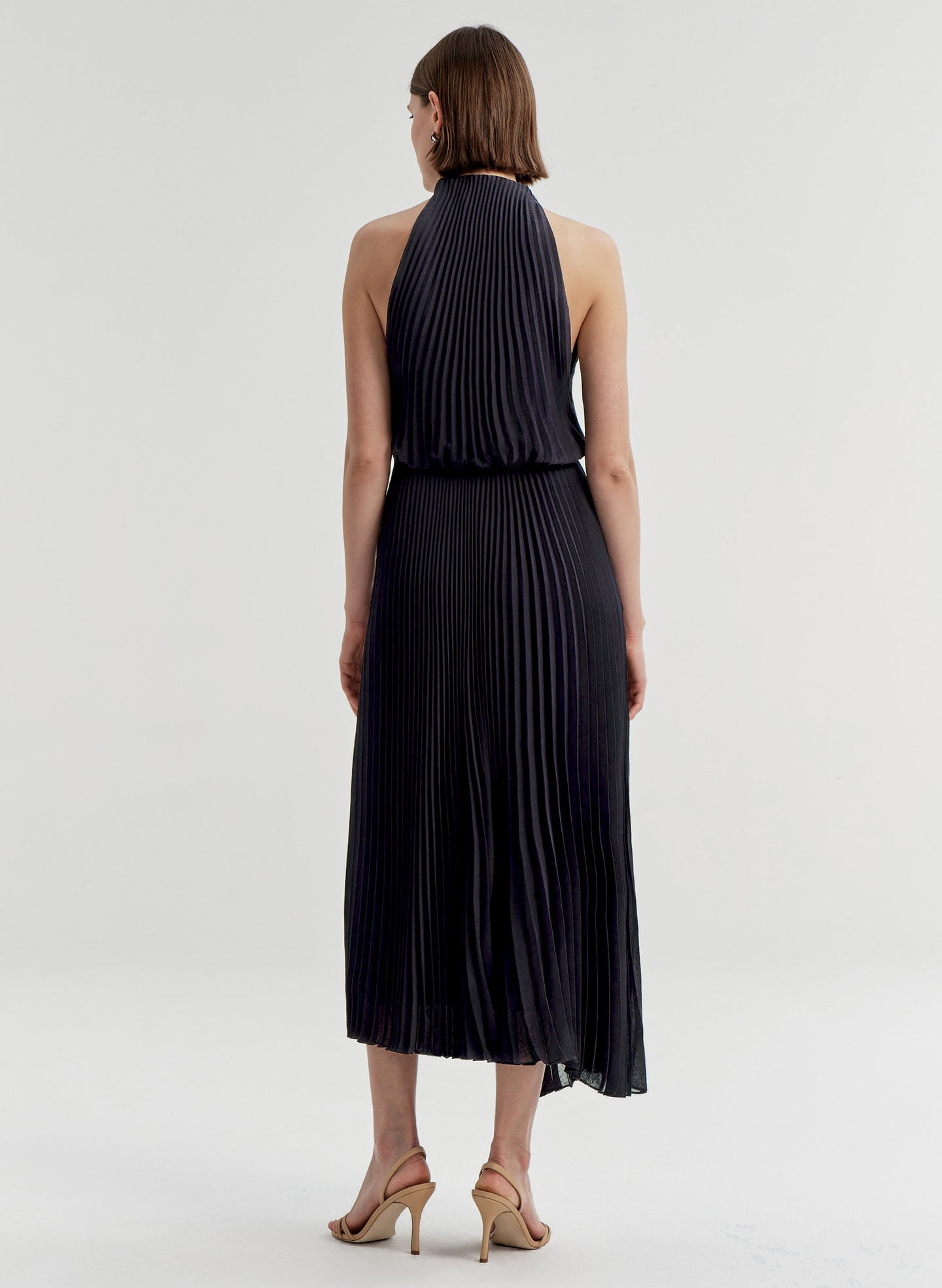 Woman wearing a blue pleated dress on a white background