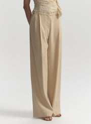 Beige wide-leg pants worn by a person on a white background