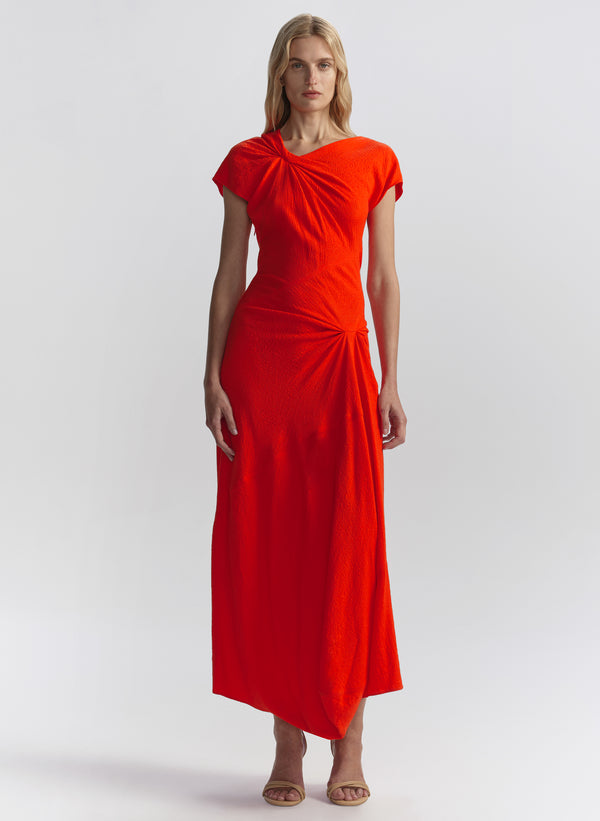 Woman wearing a red-orange dress on a white background