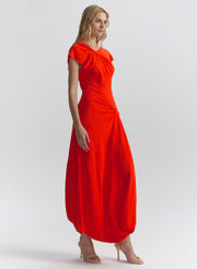 Woman wearing a red-orange dress on a white background