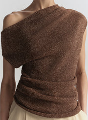Brown textured top on a woman against a plain background