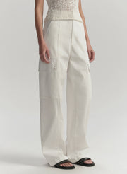 Person wearing white pants on a plain background