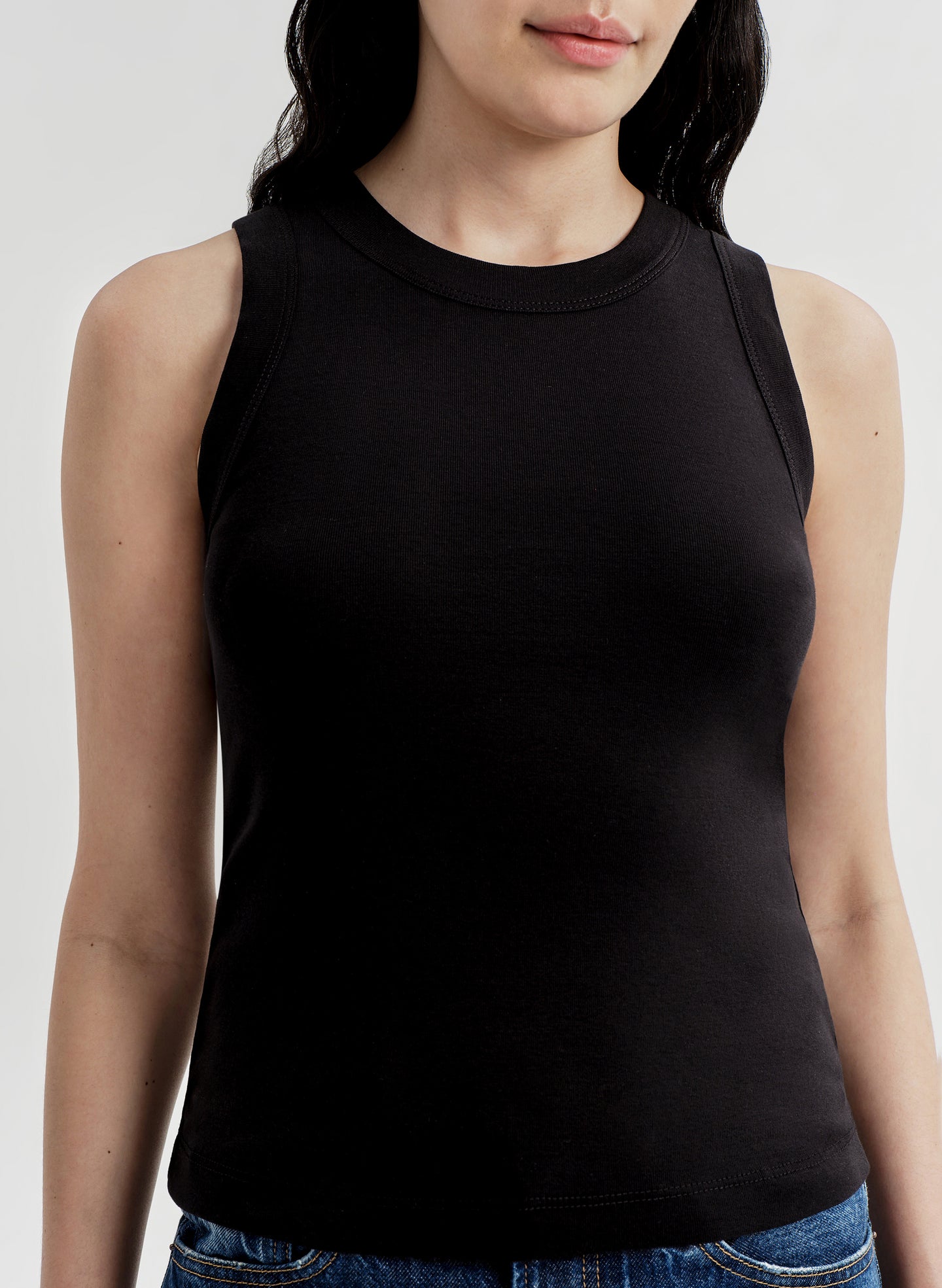 Person wearing a black sleeveless top on a white background
