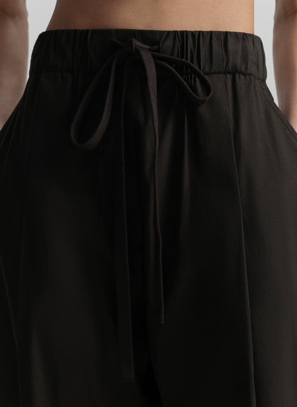 Black pants with a tie waist worn by a person