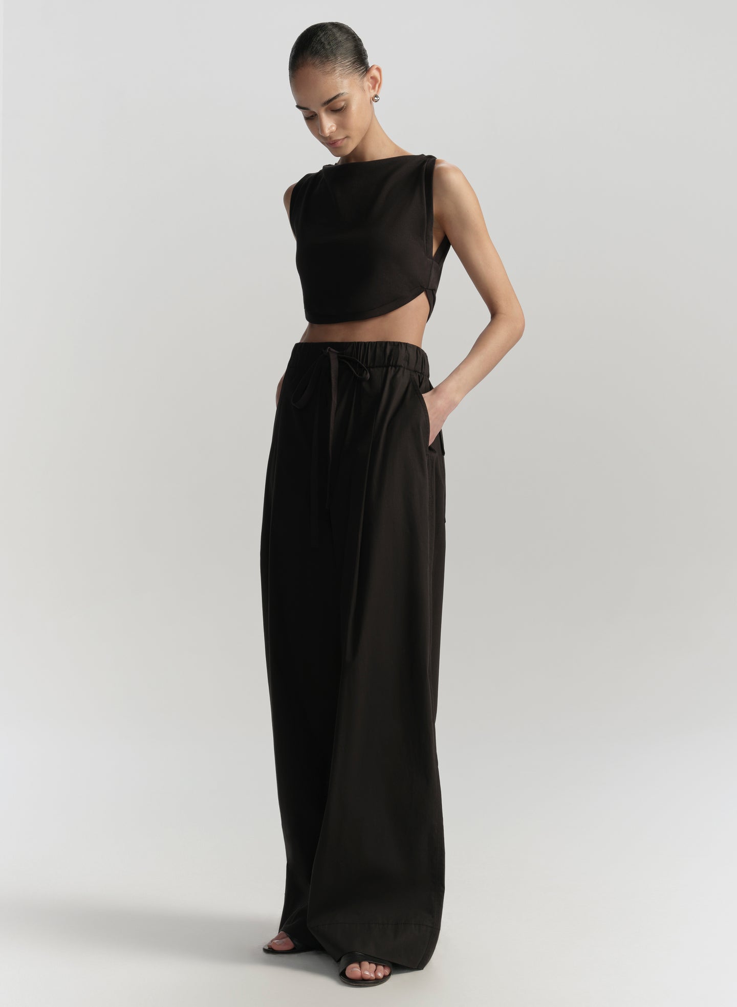 Woman wearing a black outfit on a plain background