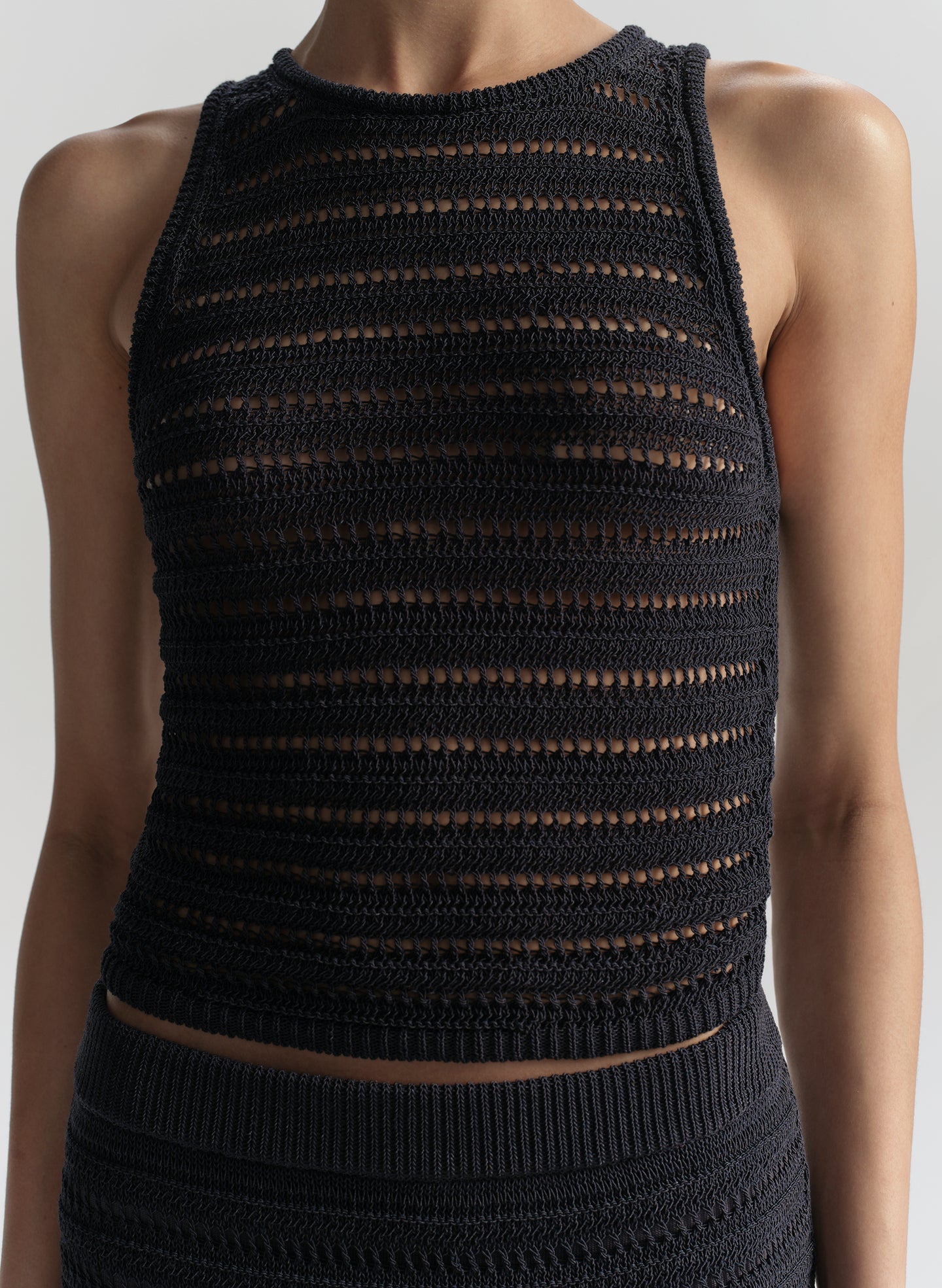 Blue knitted sleeveless top against a white background