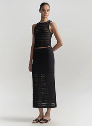 Woman wearing a blue sleeveless top and skirt set on a light gray background