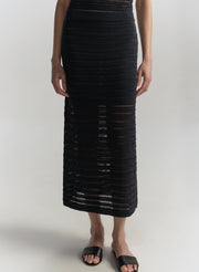 Person wearing a blue crochet skirt on a white background